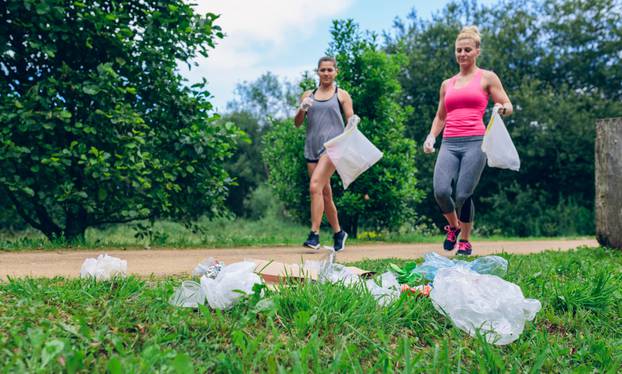 Waste,Pile,And,Two,Girls,Running,With,Bags,Doing,Plogging