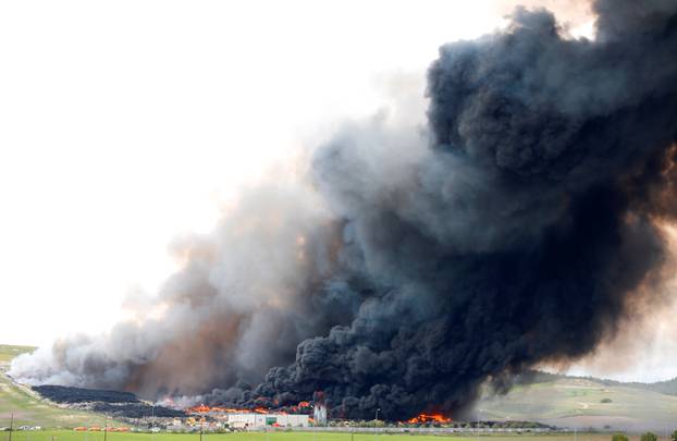 A fire rages at a tyre dump near a residential development in Sesena