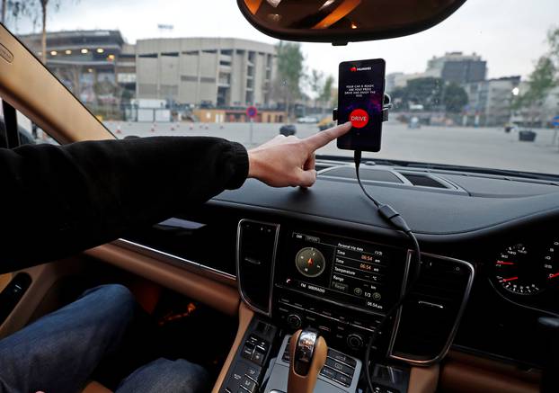 An engineer points to a Huawei Mate 10 Pro mobile used to control a driverless car during the Mobile World Congress in Barcelona