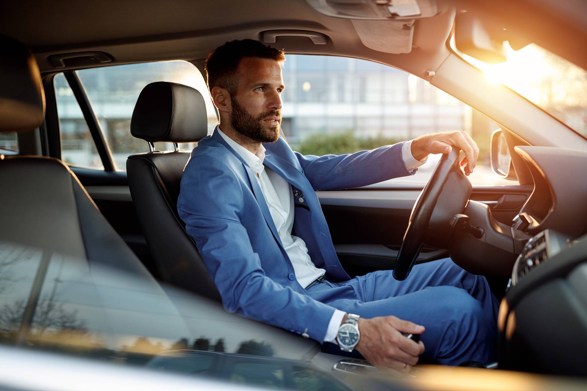 Attractive man in business suit driving car