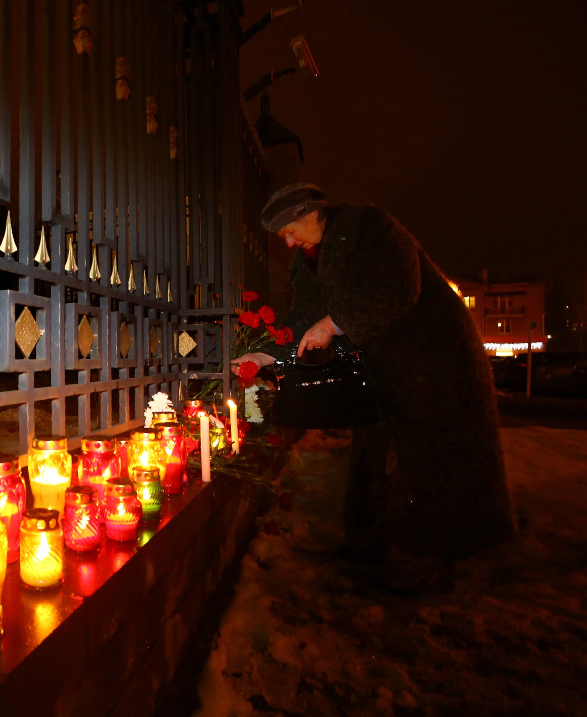 A woman lays flowers in memory of passengers and crew members of Russian military Tu-154 plane, which crashed into the Black Sea, at the Russian embassy in Minsk, Belarus