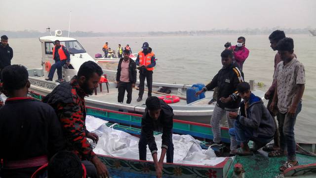 Rescue workers bring bodies on a boat, who died after a fire broke out in a passenger ferry on Sugandha River in Jhalalathi