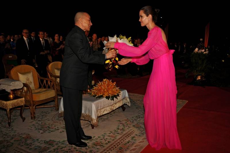 King Norodom Sihamoni of Cambodia gives a bouquet of flowers to actress Angelina Jolie after the opening ceremony of the film "First They Killed My Father" in Siem Reap