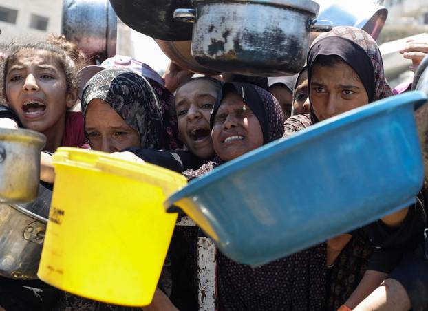 Palestinians receive food from charity kitchen, in Gaza City
