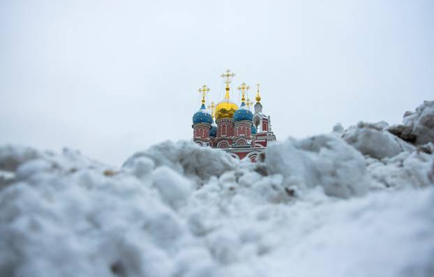 FILE PHOTO: A view shows a church behind a heap of snow in Moscow