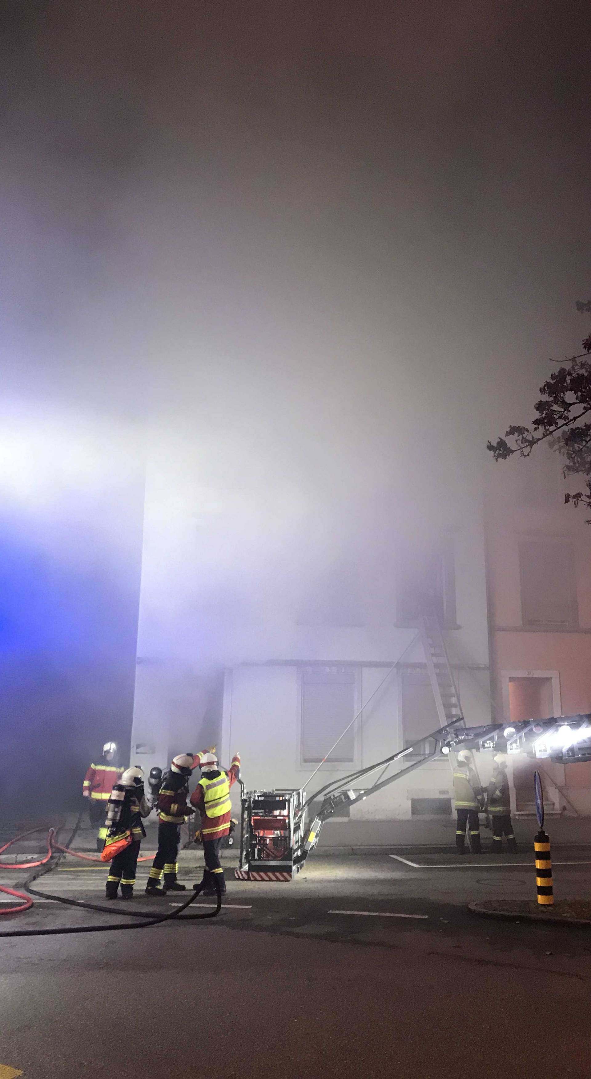 Firefighters are seen in front of a house where six people were killed in an apartment fire early on Monday morning, police said,in Solothurn