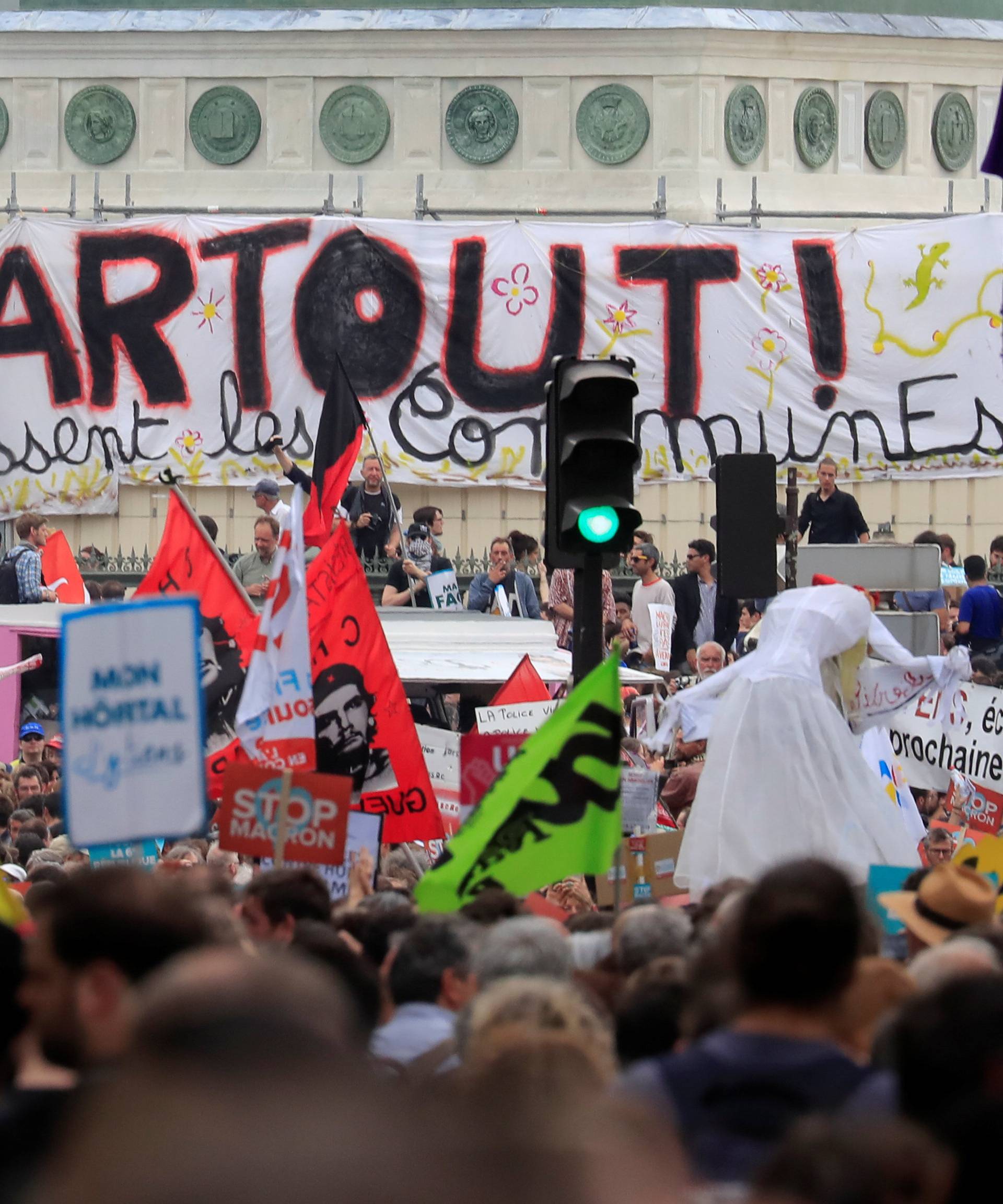 Protesters hold placards during a demonstration by French unions and France Insoumise" (France Unbowed) political party to protest against government reforms, in Paris