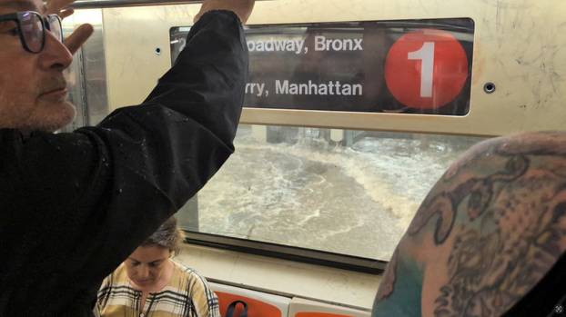 A man looks on from a subway as a station is flooded in New York