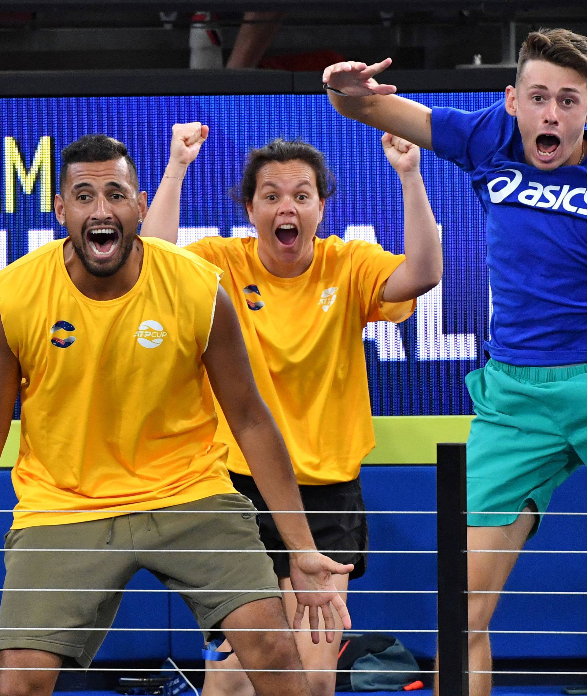 Team Australia players Kyrgios and de Minaur are seen celebrating as their team mates Guccione and Peers play their doubles match against Auger-Aliassime and Shamasdin of Canada during day 3 of the ATP Cup tennis tournament in Brisbane