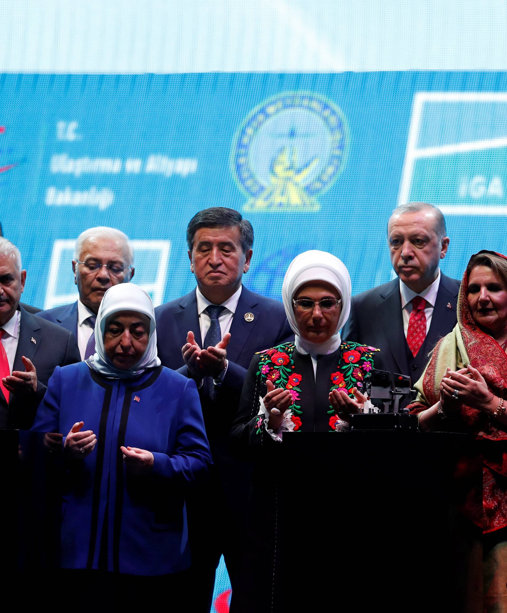 Turkey's President Erdogan, his wife Emine and officials pray on the stage during the official opening ceremony of Istanbul's new airport, in Istanbul