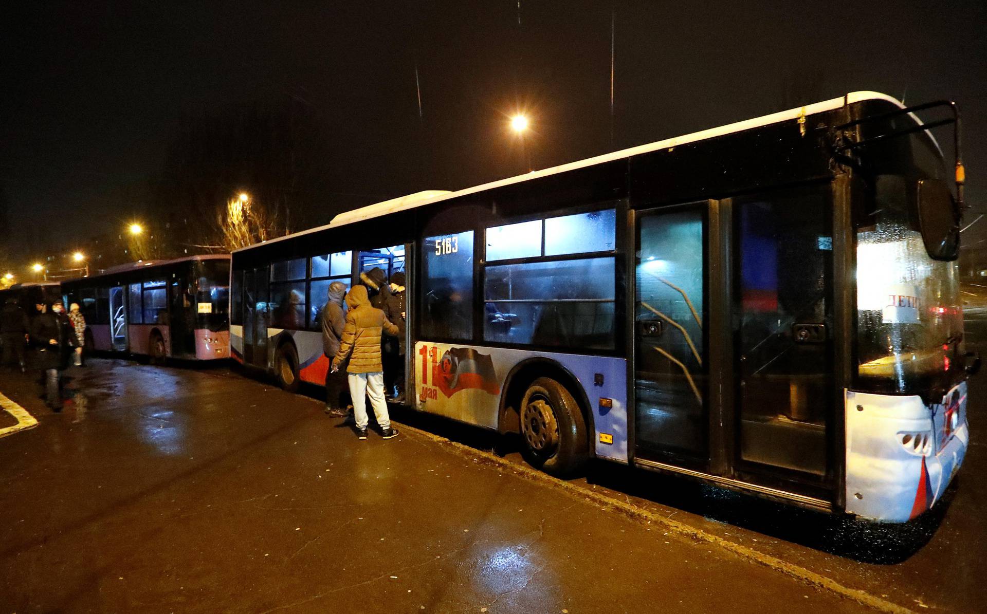 People board buses arranged to evacuate local residents, in Donetsk