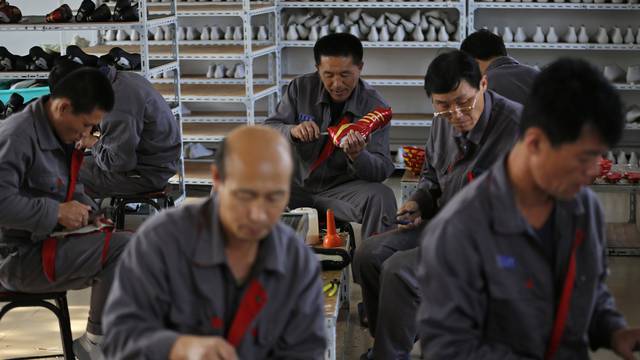 FILE PHOTO - North Korean workers make soccer shoes inside a temporary factory at a rural village on the edge of Dandong