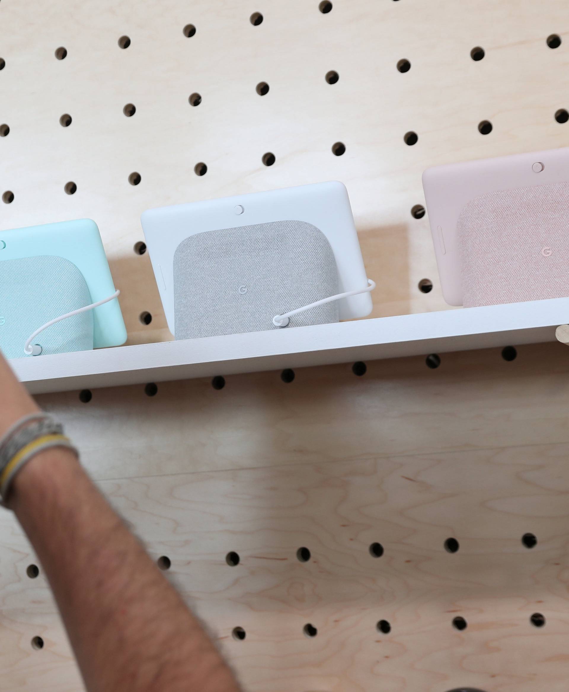 A man takes a photo of the Google Home on display after a news conference in Manhattan, New York