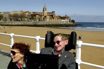 FILE PHOTO: British astrophysicist Hawking and his wife Elaine pose in front of a beach in Spain.