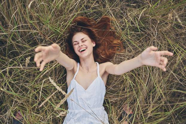cheerful Woman in a white dress lies on the grass life leisure freedom