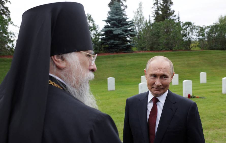 Russian President Vladimir Putin lays flowers at the graves of Soviet soldiers at Fort Richardson National Cemetery near Anchorage
