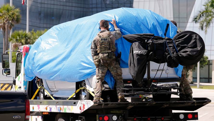 A white van seized during an investigation into a series of parcel bombs is towed into FBI headquarters in Miramar