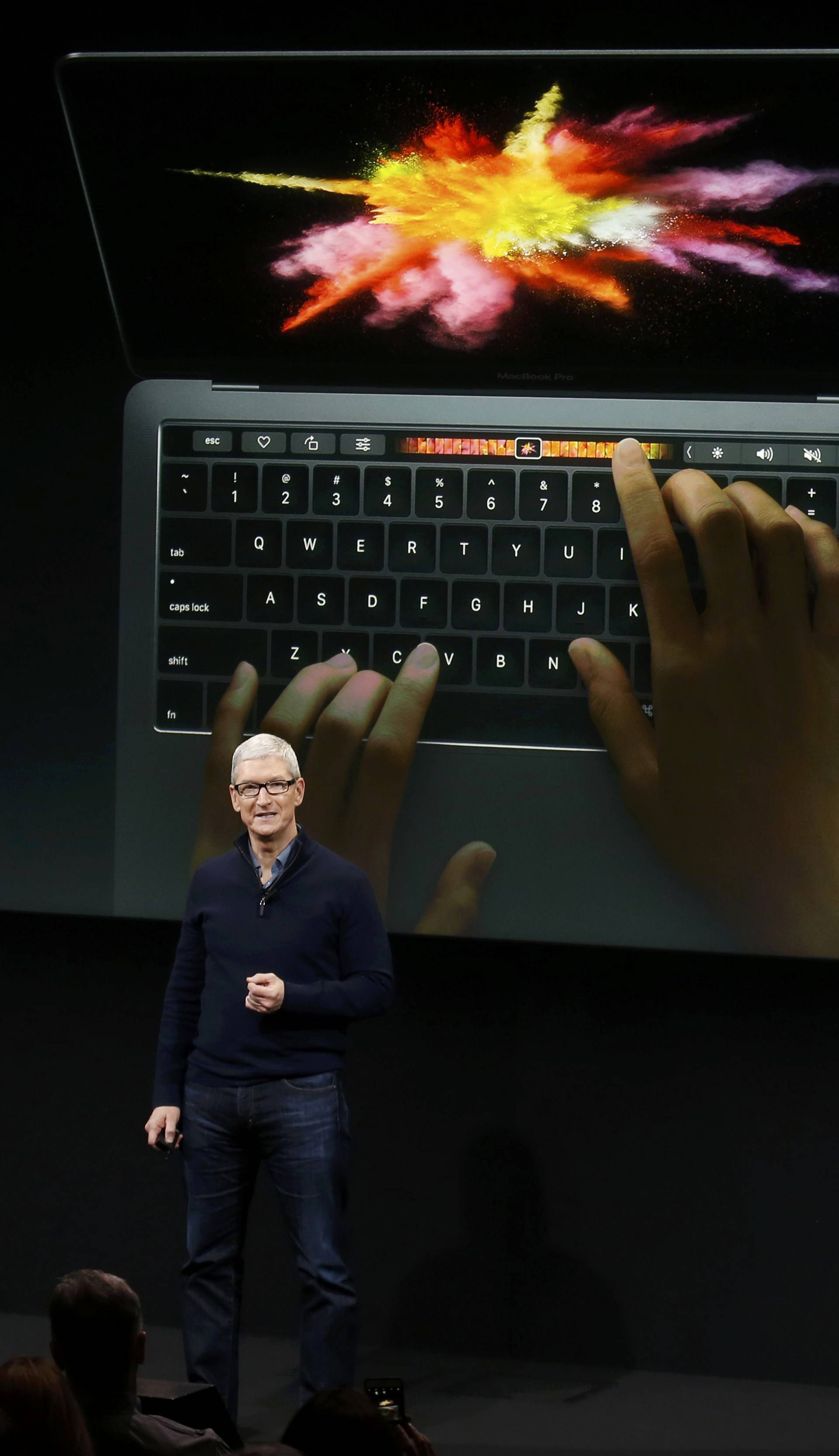 Apple CEO Tim Cook speaks under a graphic of the new MacBook Pro during an Apple media event in Cupertino