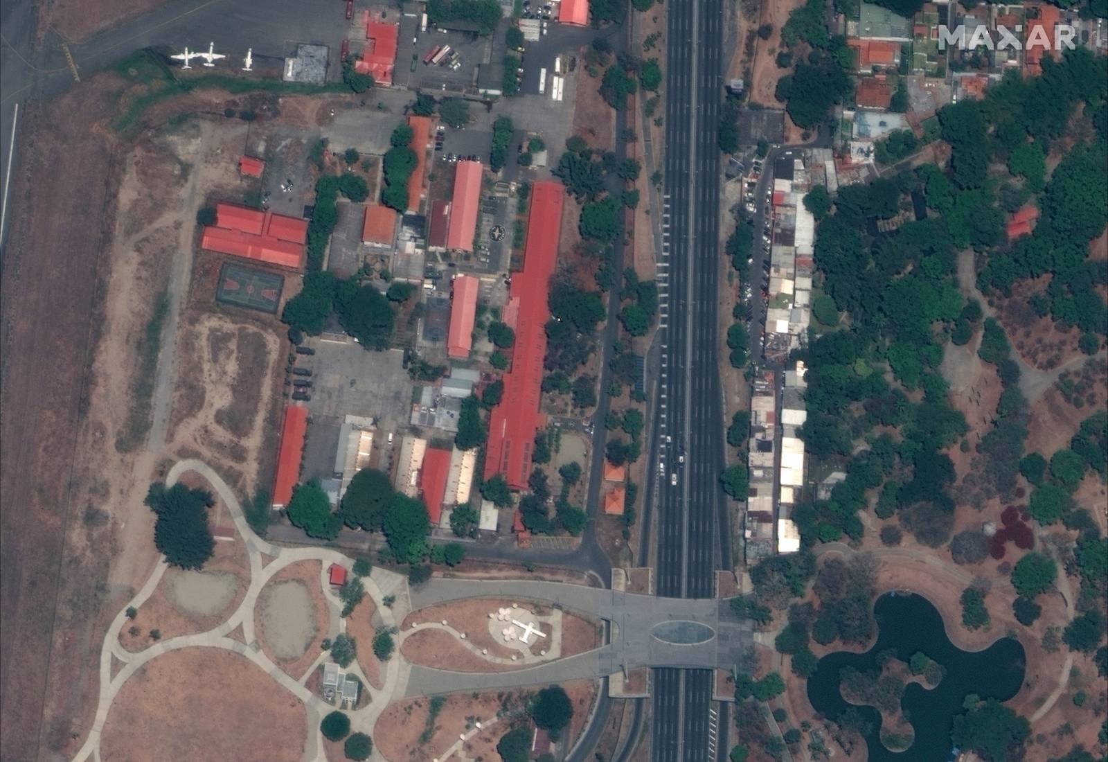 Handout photo of a satellite image of the northern edge of Francisco de Miranda airbase and security vehicles on the road, in Caracas